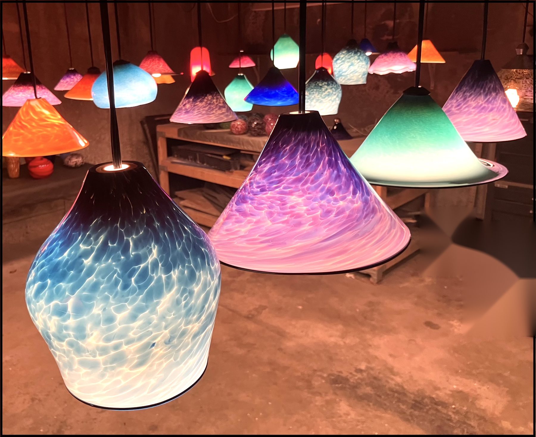 Hand-blown glass pendant lights hanging in Dominic Nicholas's studio